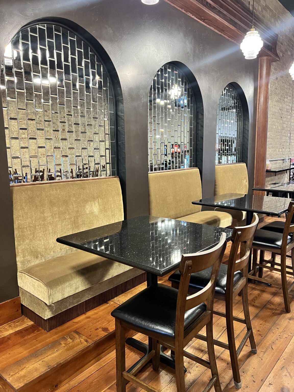 Booths and mirrored arches inside The Square Bagel Co.